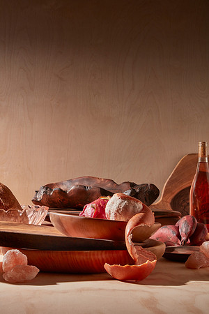 Hand made cutting boards, bowls and trays artfully arranged with fruit of similar color