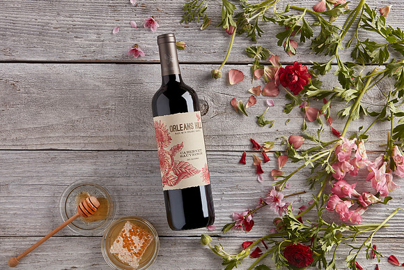 Orleans Hill Cabernet Sauvignon 2015 Wine bottle flat lay on barn wood with flowers and honey